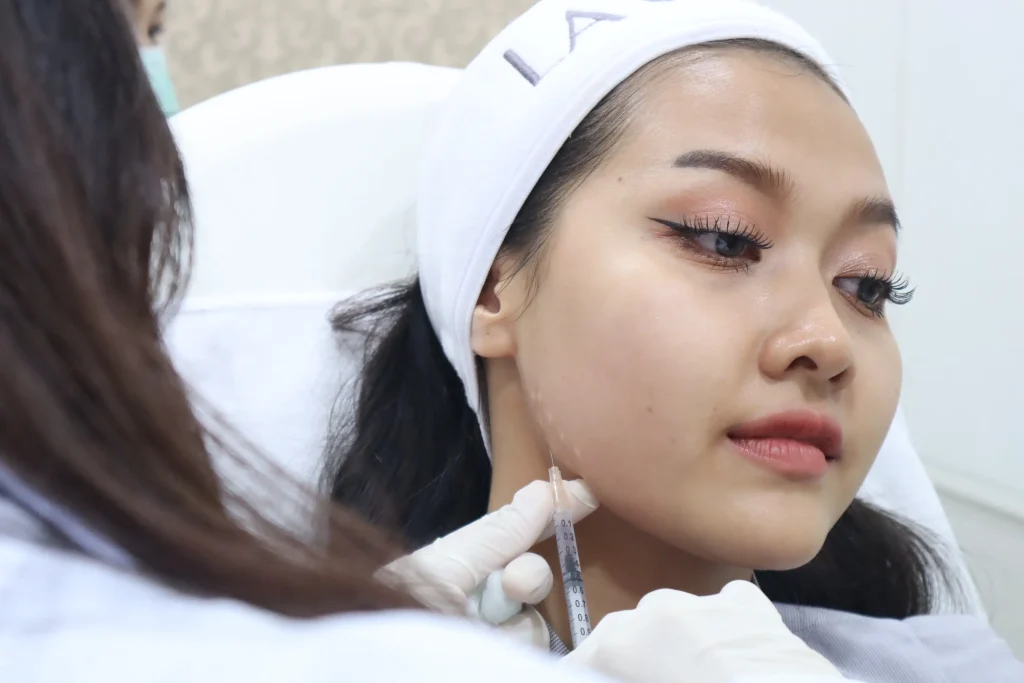แพทย์ La Grace Clinic กำลังฉีดโบท็อกซ์บริเวณกรามเพื่อปรับกรอบหน้า
