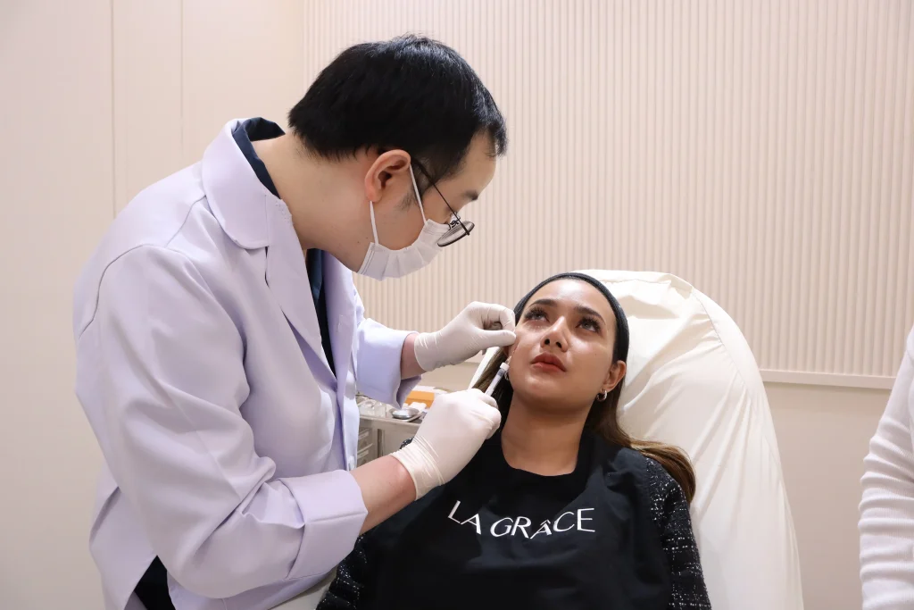 Doctor at La Grace Clinic performing under eye filler treatment
